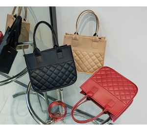 Close-up of quilted rhombic texture handbags in black beige and red colors