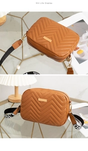 Close-up of caramel quilted crossbody bag with golden plaque and chic lettered strap