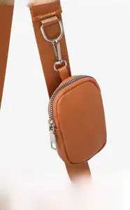 Close-up of brown textured leather coin pouch with silver zipper on wide strap