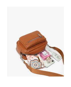 Capacity detail of the brown crossbody bag showing storage for phone and cosmetics