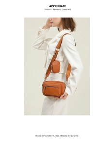 Detail of orange crossbody bag with a detachable round coin purse on fabric strap