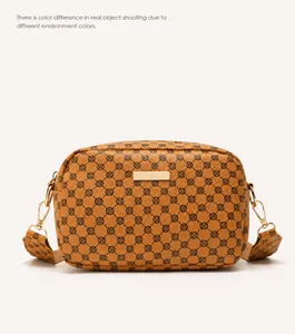 Detail of brown PU leather crossbody bag featuring vintage floral pattern and wide strap