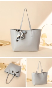Detail of light gray tote bag with a decorative silk scarf and smooth faux leather texture