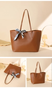 Detailed close-up of brown tote bag showing smooth faux leather texture and silk scarf