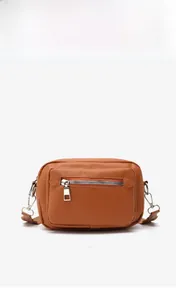 Detail of a brown synthetic leather crossbody bag featuring a silver zip pocket and metal hooks