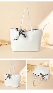 Detail view of large white pebble grain tote bag decorated with elegant black and gold silk scarf