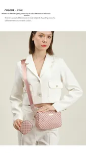 Detail of pink crossbody camera bag with logo pattern and matching heart-shaped coin purse