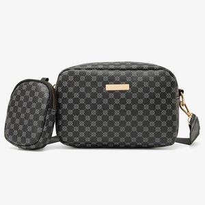 Close-up of black crossbody bag with grey clover pattern and small round coin purse