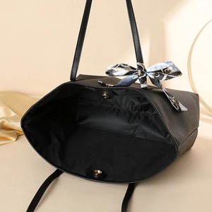 Minimalist black lychee texture tote bag with elegant blue geometric silk scarf detail