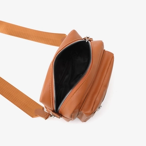 Brown minimalist shoulder bag with wide strap showing interior capacity and zipper detail