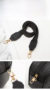Detail of adjustable nylon strap with gold lobster clasps and zipper on black quilted bag