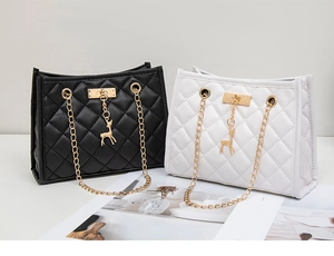 Detail of quilted leather bags with gold chain straps and signature deer charm in two colors