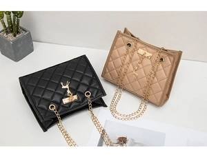 Detail of rhombic quilted crossbody bags with golden deer charm and chain straps