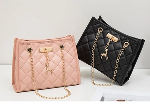 Detail of quilted leather texture and gold deer pendant on pink and black tote bags
