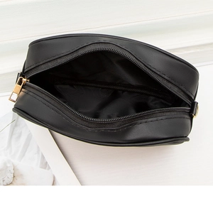 Detail view showing smooth black PU leather camera bag interior and gold zipper hardware