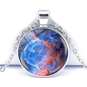 Macro shot of silver galaxy pendant with nebula pattern and domed glass cover