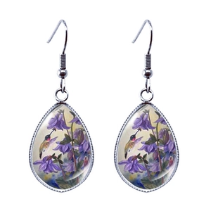 Détail de boucles d'oreilles larmes avec art de colibri et fleurs en cadre métallique