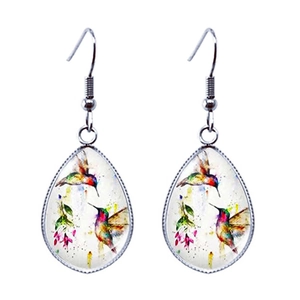 Détail de boucles d'oreilles en verre en forme de goutte avec colibri et fleurs