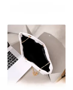 Internal view of white quilted tote bag with gold chain strap and large capacity
