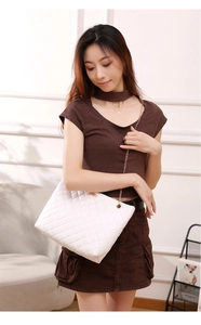 Close-up of white quilted PU leather texture with gold metal chain strap detail
