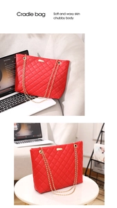 Detail of red quilted tote bag with golden chain handles and soft PU leather texture
