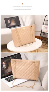Detail of apricot quilted tote bag with gold chain straps and metal buckle on table