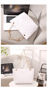 Macro shot of white quilted shoulder bag with gold hardware and chain straps