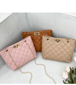 Close-up of quilted chain bags in pink, brown and beige colors with gold metal turn-lock