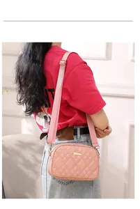 Detail of pink quilted crossbody bag with golden metal plaque and adjustable wide strap