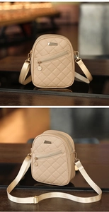 Detail view of beige quilted mini crossbody bag with metal logo and wide strap