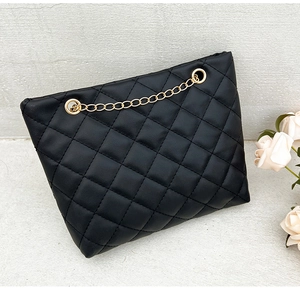 Close-up of black quilted PU leather crossbody bag with elegant gold chain strap details