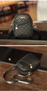 Detail of black quilted mini bag featuring gold zippers and metallic charm accents