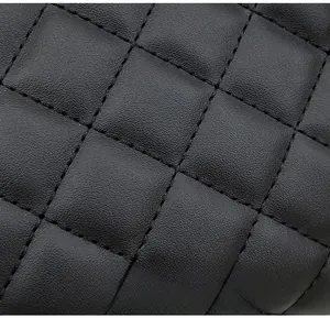 Close-up of black quilted leather material with fine diamond pattern stitching details