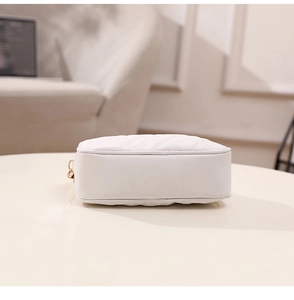 Detail view of the reinforced quilted base and precise stitching of the white crossbody bag