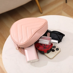 Quilted pink heart-shaped crossbody bag with gold hardware and interior item storage