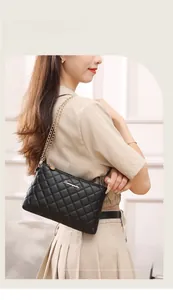 Sac bandoulière matelassé noir avec chaîne dorée et détail élégant du logo en métal