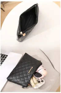 Vue détaillée du mini sac noir matelassé montrant le rangement des objets quotidiens