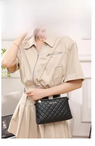 Petit sac bandoulière noir matelassé avec chaîne dorée porté par un mannequin chic