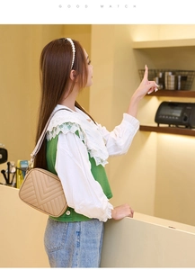 Detail der beige Kamera-Tasche mit V-förmiger Steppung und schmalem Schulterriemen