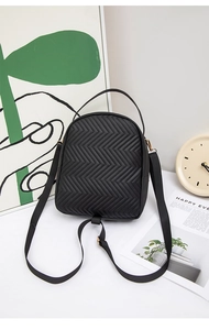 Detail of black quilted PU leather backpack with wave pattern and gold metal hardware