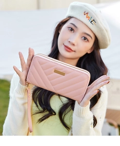 Pink quilted long clutch bag with V-pattern stitching and double zippers on model