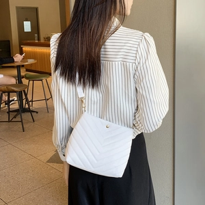 Elegant white quilted bucket bag for women with gold clasp and modern V-shaped stitching