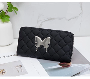 Detail of quilted black long wallet with a unique liquid-style silver butterfly ornament