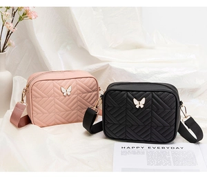 Detail view of quilted cross-body bags in black and pink with butterfly embellishments