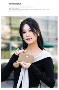 Brown quilted coin purse with a butterfly detail and plush pompom held by a model