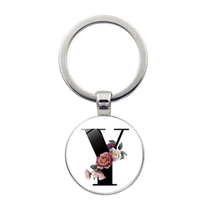 Détail d'un porte-clés argenté avec pendentif lettre Y florale sur fond blanc