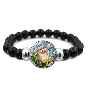 Detail van kralenarmband met Corgi olieverfschilderij bedeltje en zwarte glanzende kralen