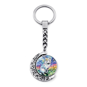 Rotating crescent moon keychain featuring double-sided white wolf impressionist art detail