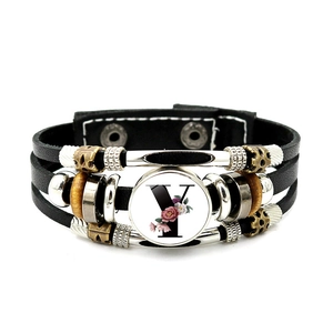 Detail view of leather bracelet featuring a glass pendant with letter Y and flower motif