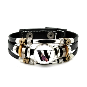 Detail of multi-layer leather bracelet featuring a vintage floral letter W glass pendant